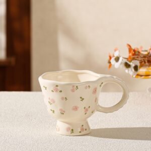 A hand-painted ceramic coffee mug with a pink floral pattern